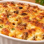 Тава с печени макарони и гъби със златиста запечена коричка, поръсени с магданоз.