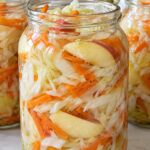 Домашна туршия от зеле, резени ябълки и моркови в големи стъклени буркани