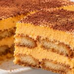 pravoagalno-parche-sloest-desert-s-bishkoti-oranzhev-krem-i-kakao-povdignato-s-shpatula-ot-byala-tava